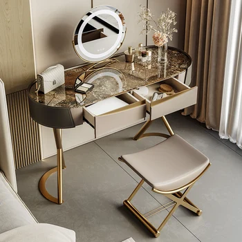 В спальне с роскошным шиферным комодом в итальянском стиле установлен современный простой дизайнерский столик для творчества небольшого размера высокого класса.